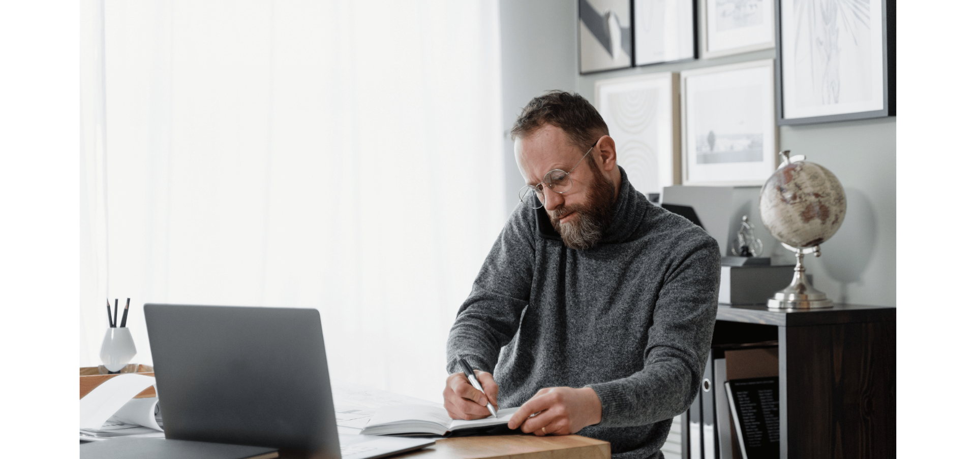 Man on the phone while making notes - Stafftax | The Challenges of DIY Payroll
